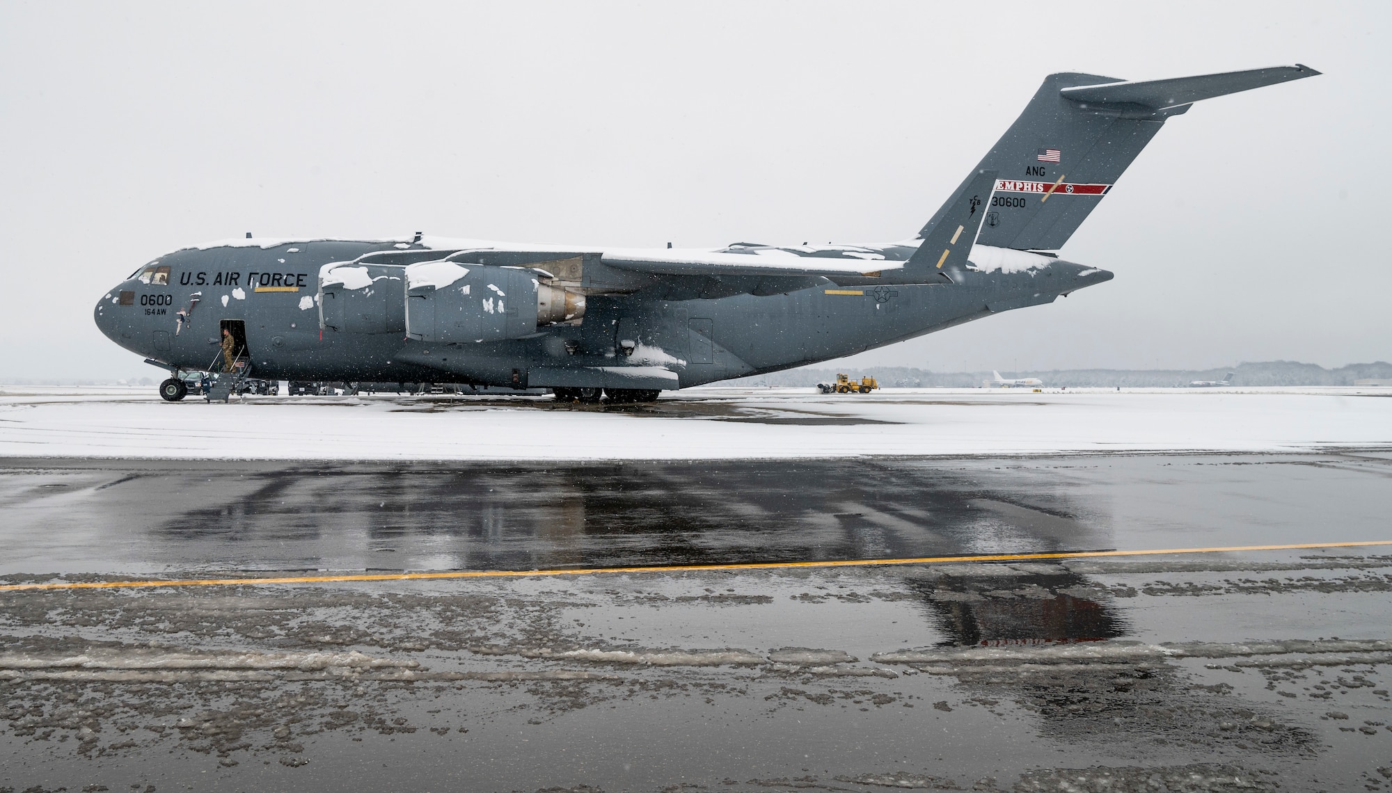 A snow-covered Tennessee Air National Guard C-17 Globemaster III sits on the flight line at Dover Air Force Base, Delaware, Feb. 11, 2021. As snow fell, the base continued normal operations and prepared for additional winter weather. (U.S. Air Force photo by Senior Airman Christopher Quail)