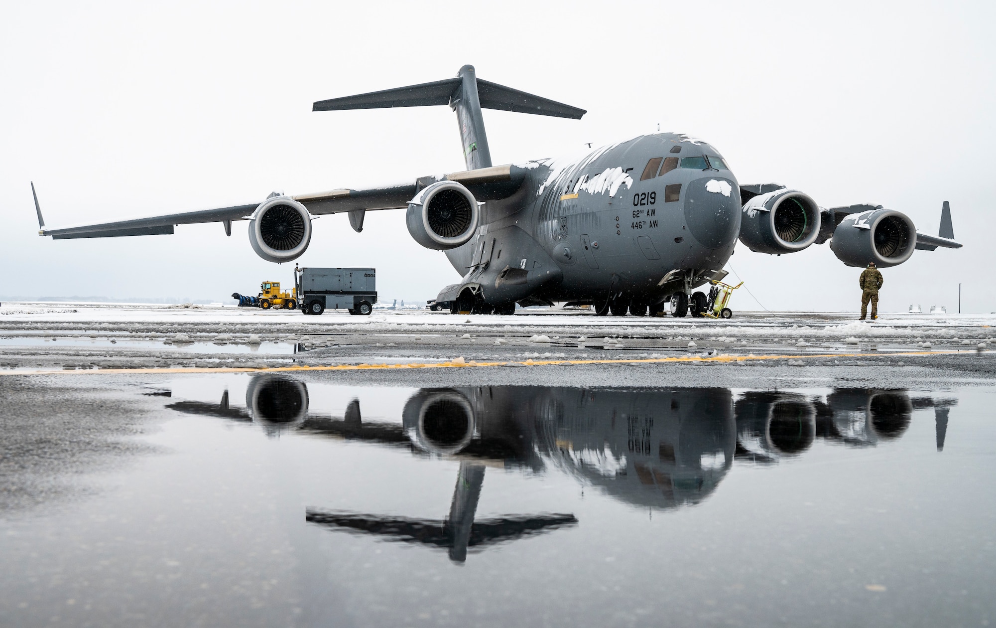 A snow-covered C-17 Globemaster III, assigned to the 62nd Airlift Wing at Joint Base Lewis-McChord, Washington, sits on the flight line at Dover Air Force Base, Delaware, Feb. 11, 2021. As snow fell, the base continued normal operations and prepared for additional winter weather. (U.S. Air Force photo by Senior Airman Christopher Quail)