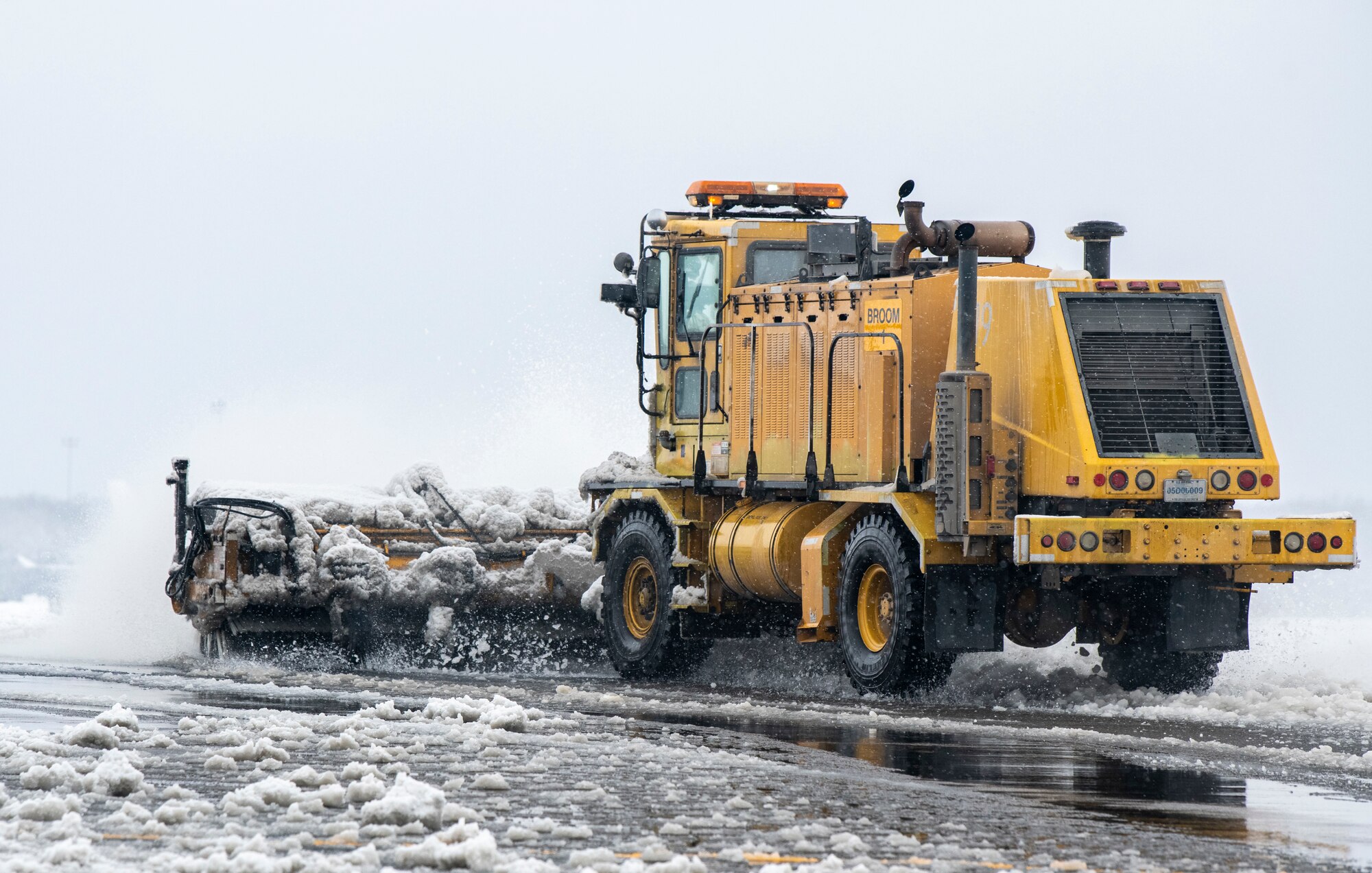 A 436th Civil Engineer Squadron runway sweeper clears snow from the flight line at Dover Air Force Base, Delaware, Feb. 11, 2021. As snow fell, the base continued normal operations and prepared for additional snowfall. (U.S. Air Force photo by Senior Airman Christopher Quail)