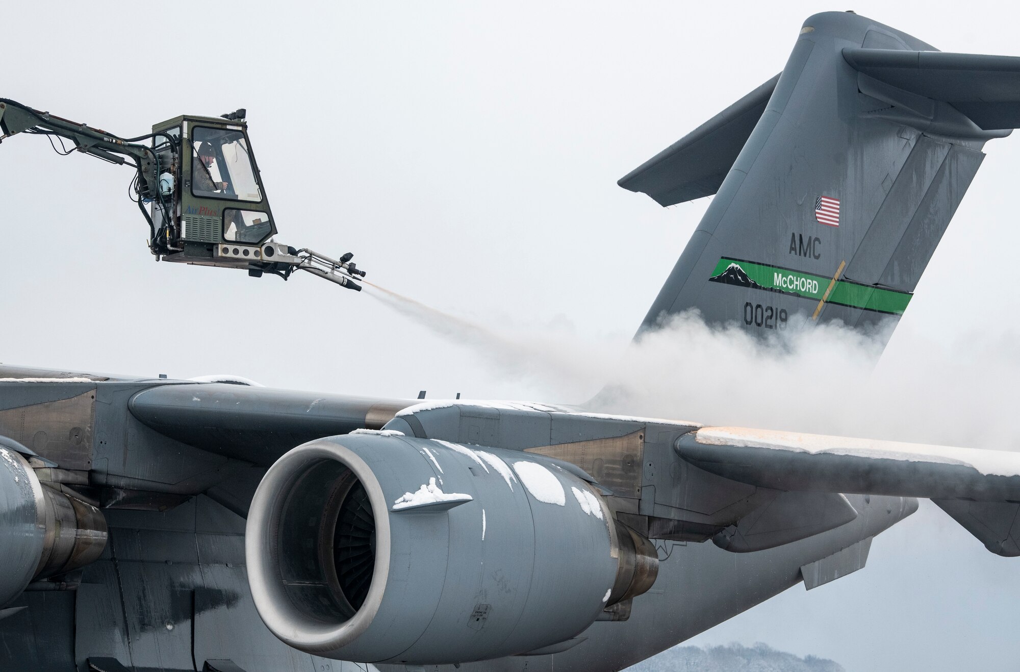 A de-icing vehicle removes snow from the left wing of a transient C-17 Globemaster III, assigned to the 62nd Airlift Wing Joint Base Lewis-McChord, Washington, prior to departing Dover Air Force Base, Delaware, Feb. 11, 2021. Because snow and ice can change the shape of an aircraft's wings and tail, the de-icing process is very important in ensuring a smooth and safe flight. (U.S. Air Force photo by Senior Airman Christopher Quail)