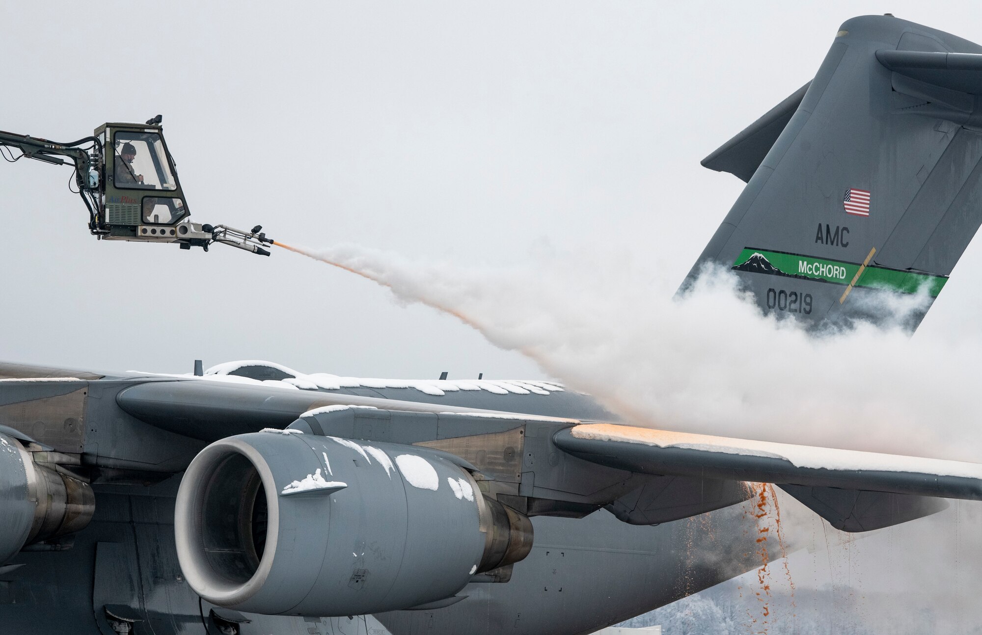 A de-icing vehicle removes snow from the left wing of a transient C-17 Globemaster III, assigned to the 62nd Airlift Wing Joint Base Lewis-McChord, Washington, prior to departing Dover Air Force Base, Delaware, Feb. 11, 2021. Because snow and ice can change the shape of an aircraft's wings and tail, the de-icing process is very important in ensuring a smooth and safe flight. (U.S. Air Force photo by Senior Airman Christopher Quail)