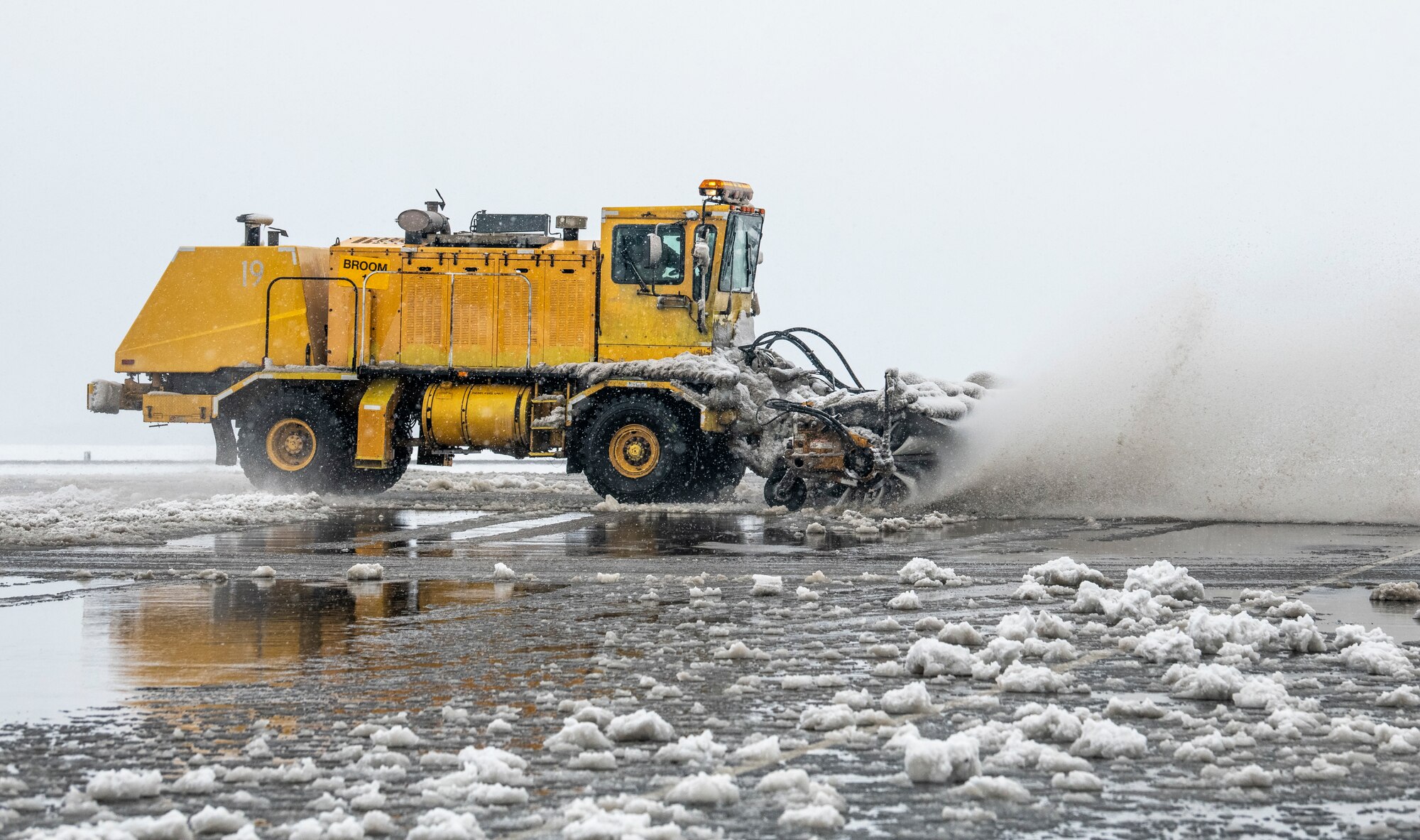 A 436th Civil Engineer Squadron runway sweeper clears snow from the flight line at Dover Air Force Base, Delaware, Feb. 11, 2021. As snow fell, the base continued normal operations and prepared for additional snowfall. (U.S. Air Force photo by Senior Airman Christopher Quail)
