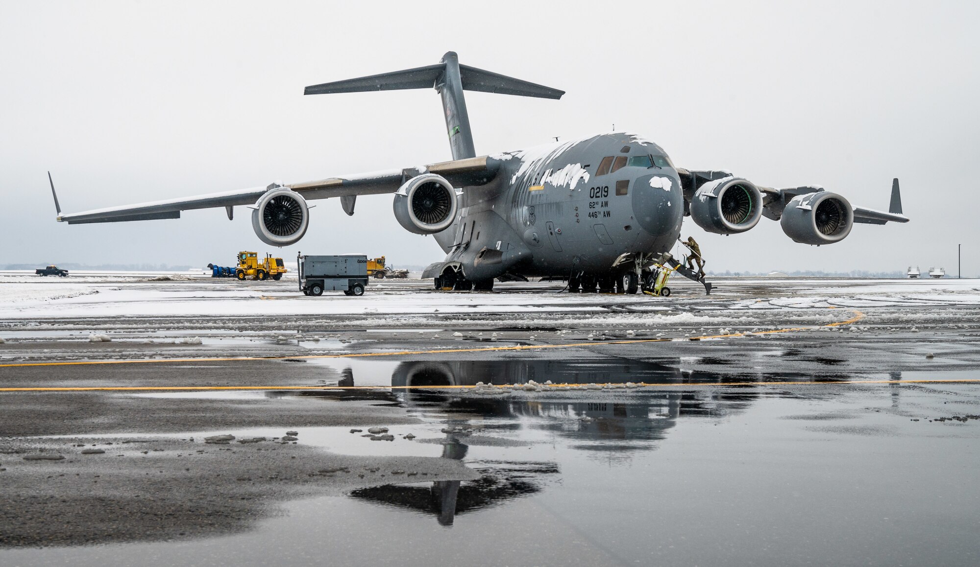 A snow-covered C-17 Globemaster III, assigned to the 62nd Airlift Wing at Joint Base Lewis-McChord, Washington, sits on the flight line at Dover Air Force Base, Delaware, Feb. 11, 2021. As snow fell, the base continued normal operations and prepared for additional winter weather. (U.S. Air Force photo by Senior Airman Christopher Quail)