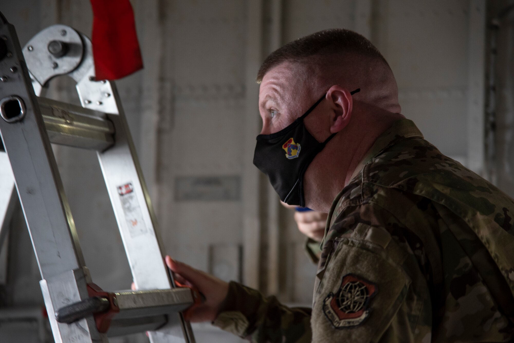 U.S. Chief Master Sgt. Chad Bickley, 18th Air Force command chief, climbs a ladder to inspect the landing gear on a KC-135 Stratotanker aircraft Feb. 18, 2021, at MacDill Air Force Base, Fla.