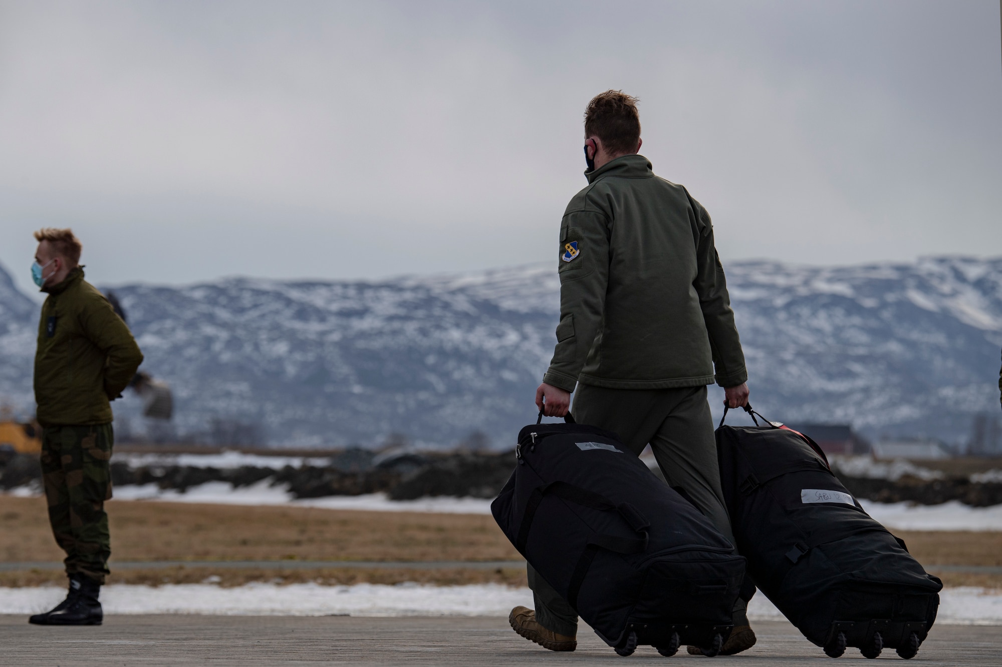An Airman assigned to the 9th Expeditionary Squadron walks toward a bus at Ørland Air Force Station, Norway, Feb. 22, 2021. The 9th EBS deployed to Norway in support of a Bomber Task Force deployment where they will integrate with ally and partner forces. Integrating with the Royal Norwegian Air Force in the European Theater and the Arctic provides specific and thorough training experience for aircrew. (U.S. Air Force photo by Airman 1st Class Colin Hollowell)