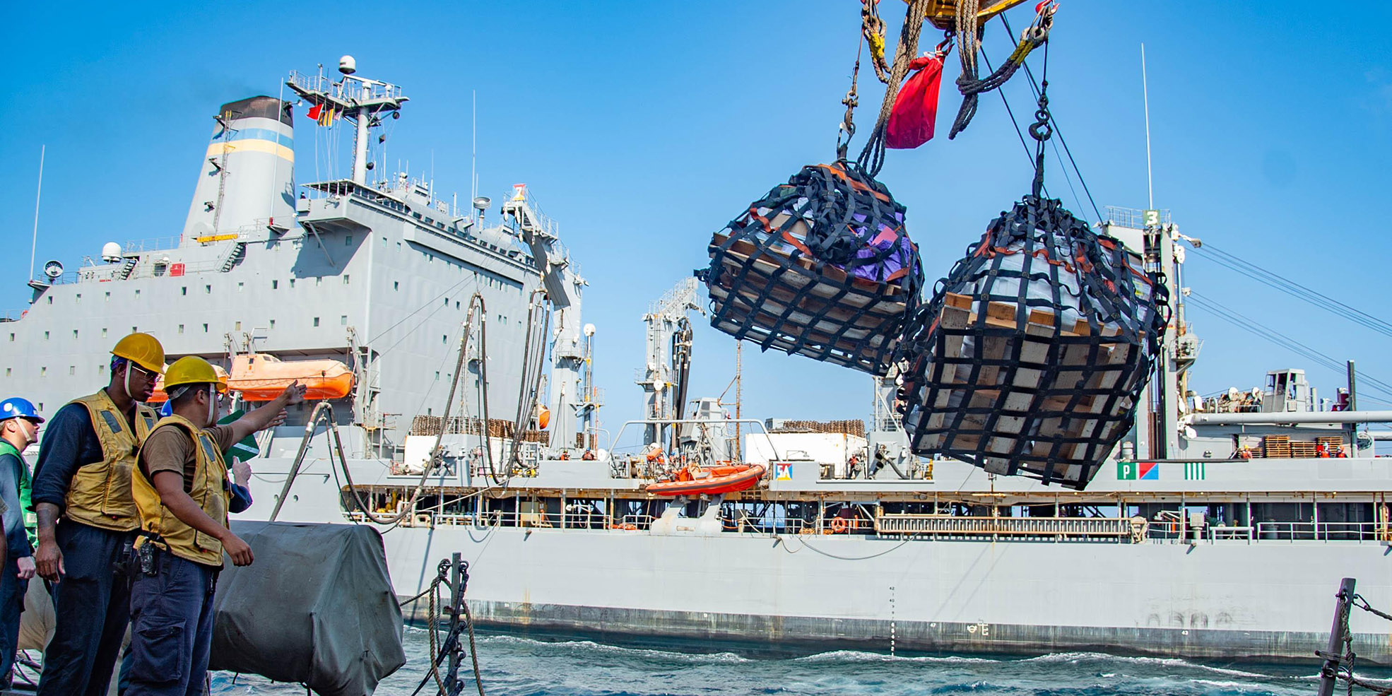 Sailors aboard the guided-missile destroyer USS Winston S. Churchill (DDG 81) send pallets to the fleet replenishment oiler USNS Leroy Grumman (T-AO 195) during a replenishment-at-sea in the Arabian Sea, Jan. 19, 2021.