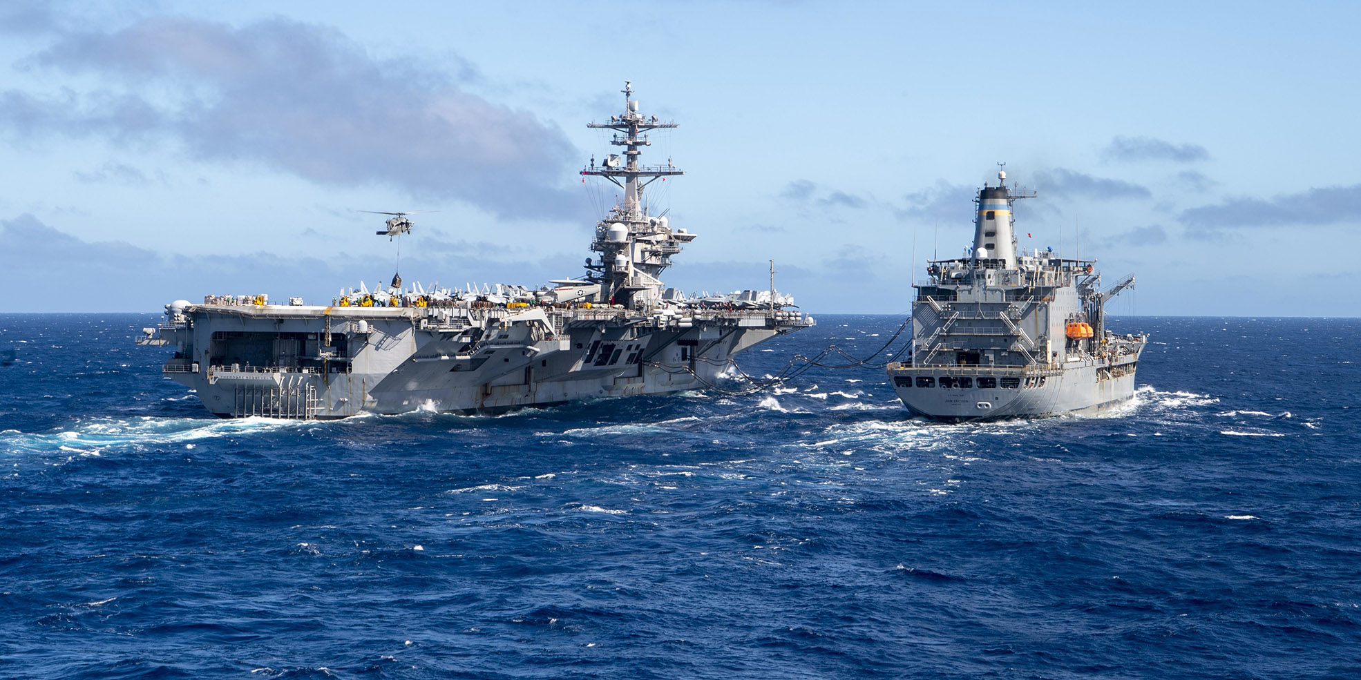 The aircraft carrier USS Theodore Roosevelt (CVN 71), left, receives fuel and supplies from the Military Sealift Command fleet replenishment oiler USNS John Ericsson (T-AO 194), Jan. 16, 2021.
