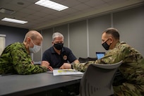 XVIII Airborne Corps Assistant Commanding General Canadian Brig. Gen. Robert Ritchie, Joint Task Force Civil Support (JTF-CS) Deputy to the Commanding General Michael Collins, and Army Col. Adam Ake, assigned to the 78th Training Division, based out of Fort Dix, N.J., discuss unit force flow in preparation for a command post exercise on Fort Bragg, N.C., Feb. 22, 2021.
