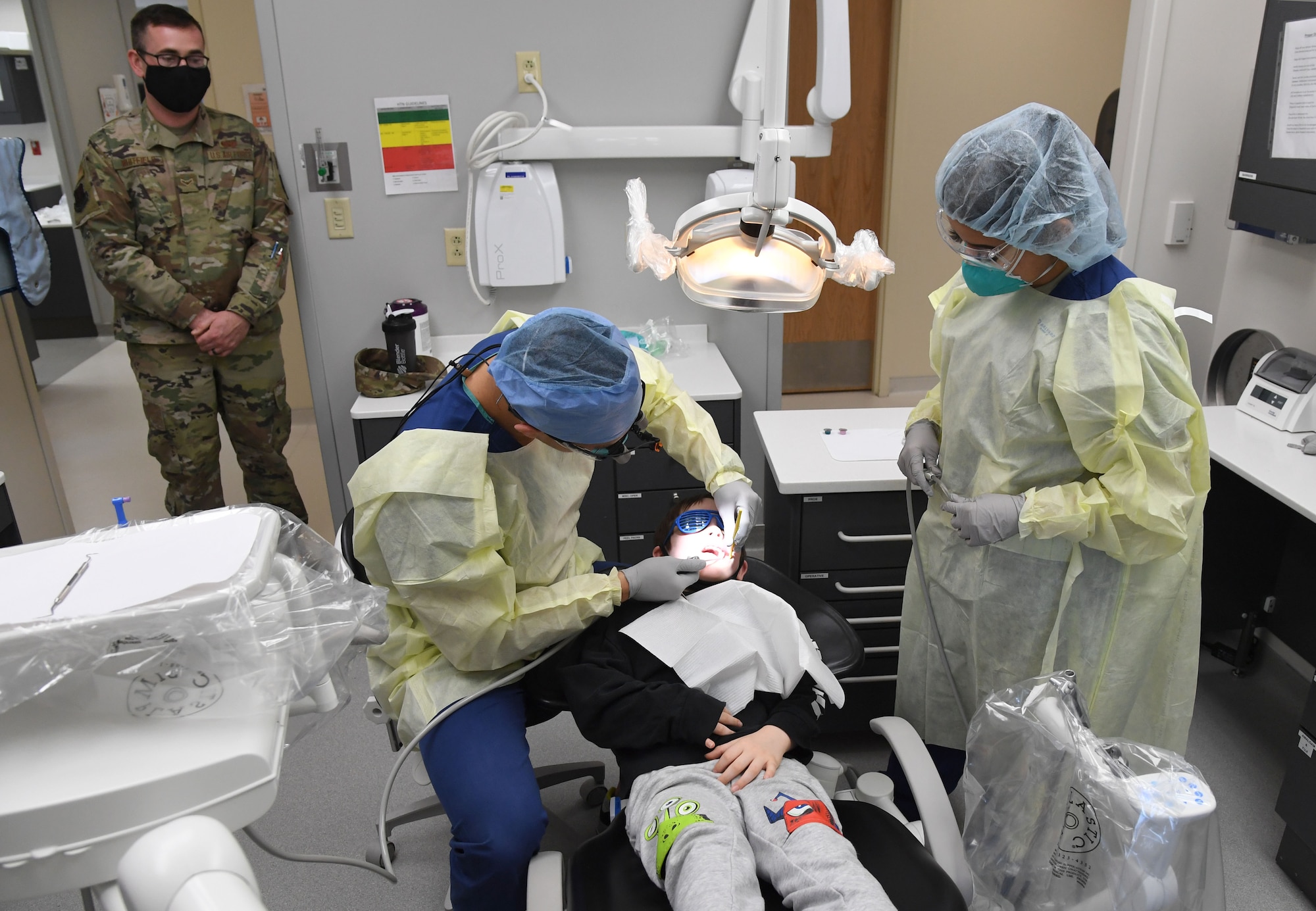 Members of the 81st Dental Squadron conduct a dental exam on a patient during the 10th Annual Give Kids a Smile Day at the dental clinic inside the Keesler Medical Center at Keesler Air Force Base, Mississippi, Feb. 17, 2021. The event was held in recognition of National Children's Dental Health Month and included free dental exams and cleanings for children ages 1-12. (U.S. Air Force photo by Kemberly Groue)