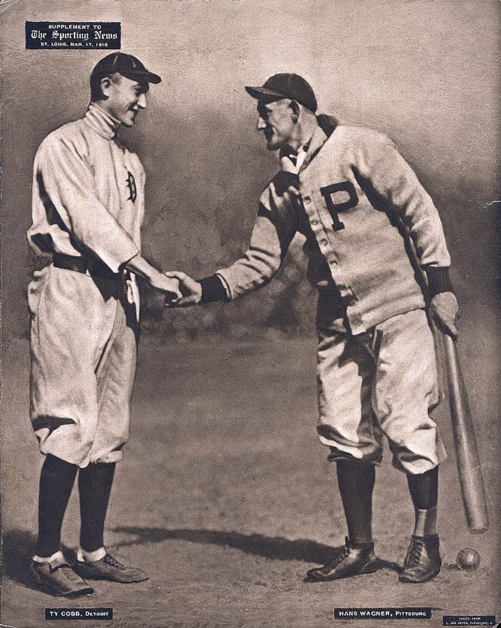 Two men in baseball uniforms shake hands.