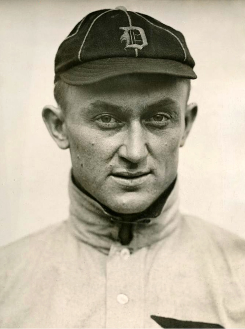A man in a baseball uniform poses for a photo.