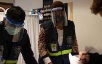From left, Patrick Cheng and Alizeta Diallo, both Federal Emergency Management Agency emergency management specialists, check-in patients at First Baptist Church of Lincoln Gardens in Somerset, N.J., Feb. 17, 2021.