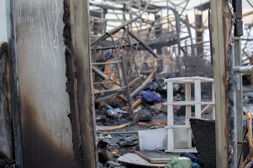 Rubble is seen in what appears to have once been a room. Sunlight can be seen shining in through where a roof might once have been.