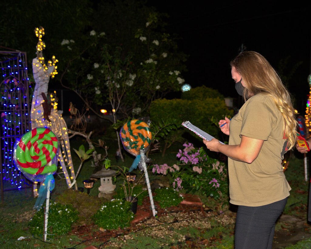 Tech. Sgt. Brittany Wallace, from the 36th Healthcare Operations Squadron, judges decorations during the Agat Mayor’s Office Christmas Yard Decoration Contest in Agat, Guam, Dec. 18, 2020.