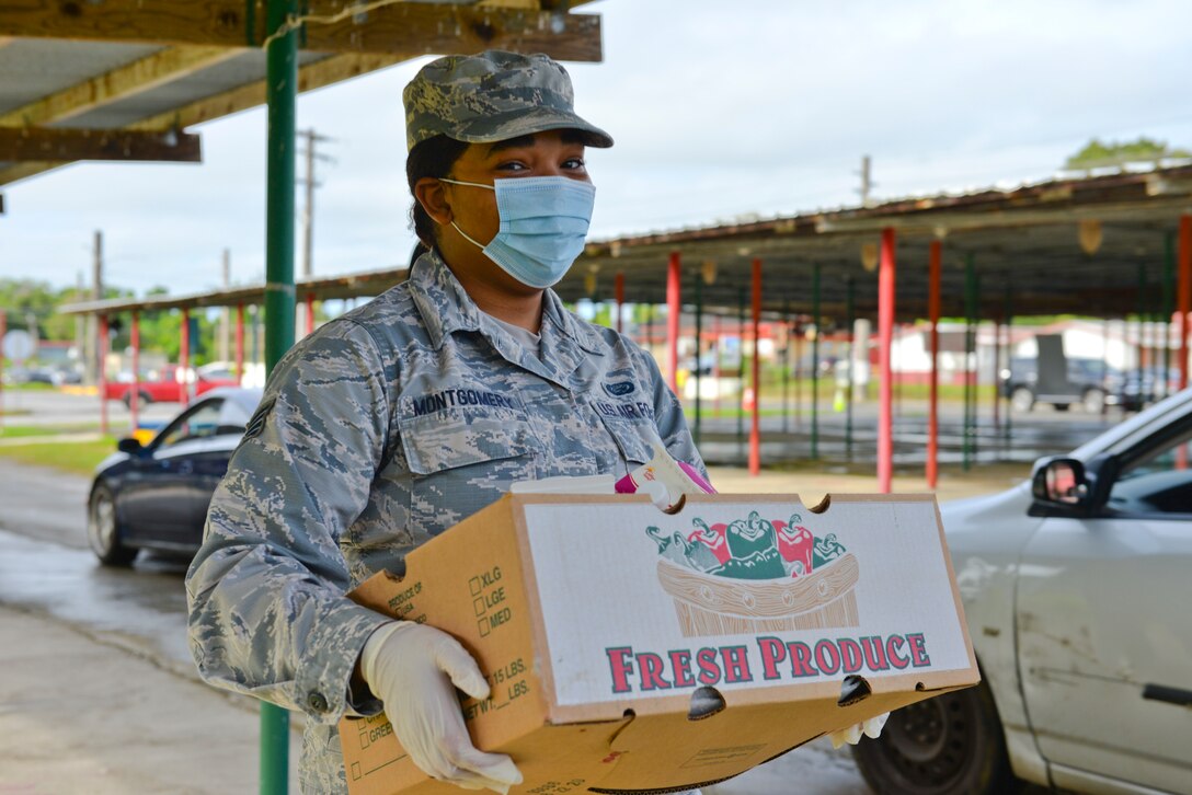 Staff Sgt. Mira Montgomery, assigned to the 36th Force Support Squadron, prepares to place a box of food into a village resident’s vehicle during a COVID-19 relief food distribution event Oct. 20, 2020 at the Mangilao village fair grounds on Guam.