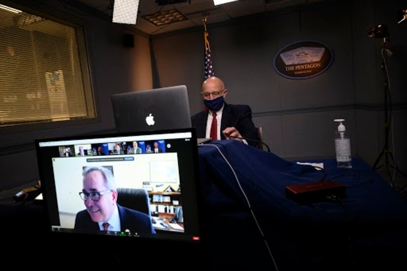 A man speaks virtually at a symposium.