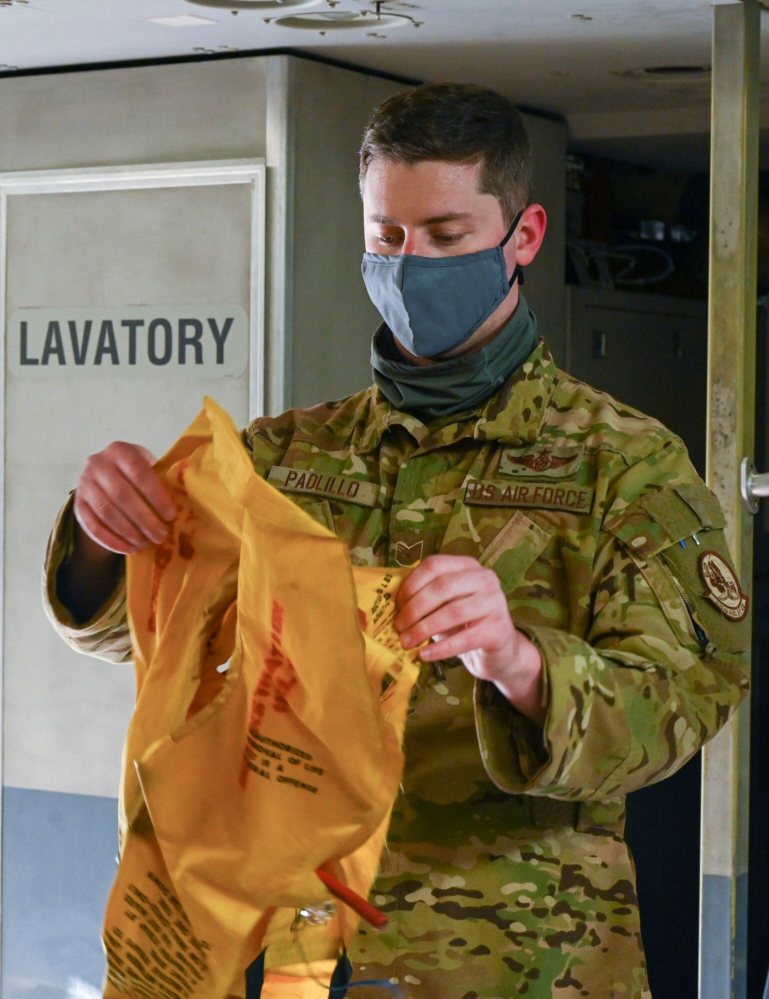 Staff Sgt. Angel Padillo, 709th Airlift Squadron C-5M Super Galaxy flight engineer, demonstrates the proper use of a life vest as part of the Liberty Eagle Readiness Exercise at Dover Air Force Base, Delaware, Feb. 17, 2021. The exercise evaluated Team Dover’s ability to rapidly deploy Airmen, Guardians and equipment with limited notice. (U.S. Air Force photo by Airman First Class Cydney Lee)