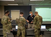 Kevin Woodrum, a Joint Task Force Civil Support (JTF-CS) exercise planner and scenario manager, speaks with task force liaison officers assigned to the 129th Combat Sustainment Support Battalion, the 44th Medical Brigade, and the 20th Engineer Brigade during a command post training exercise on Fort Bragg, N.C., Feb. 23, 2021.