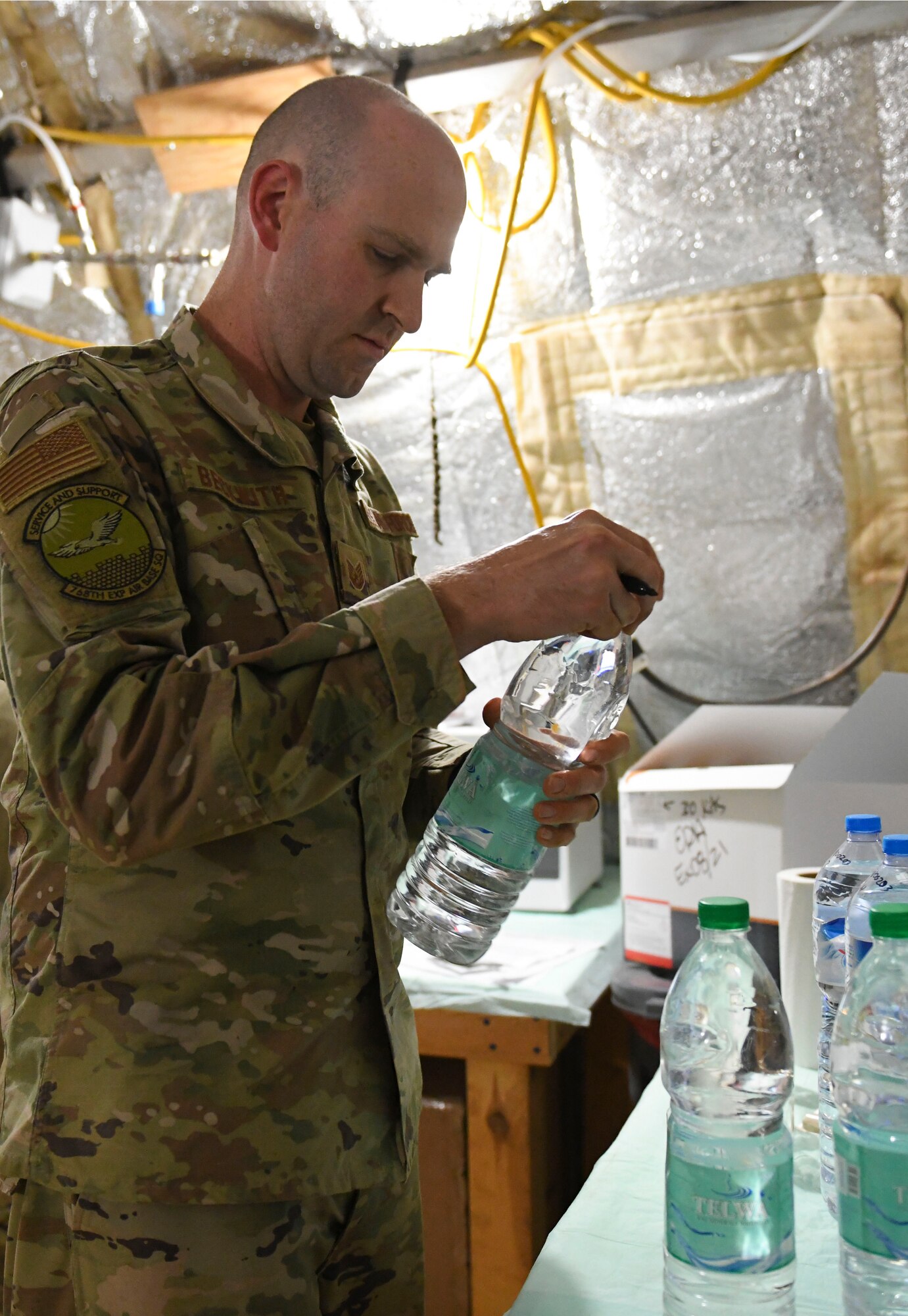 U.S. Air Force Tech. Sgt. Kristopher Beckwith, 768th Expeditionary Air Base Squadron bioenvironmental engineer, labels tested water bottles with the date and time at Nigerien Air Base 101, Niamey, Niger, Feb. 16, 2021.