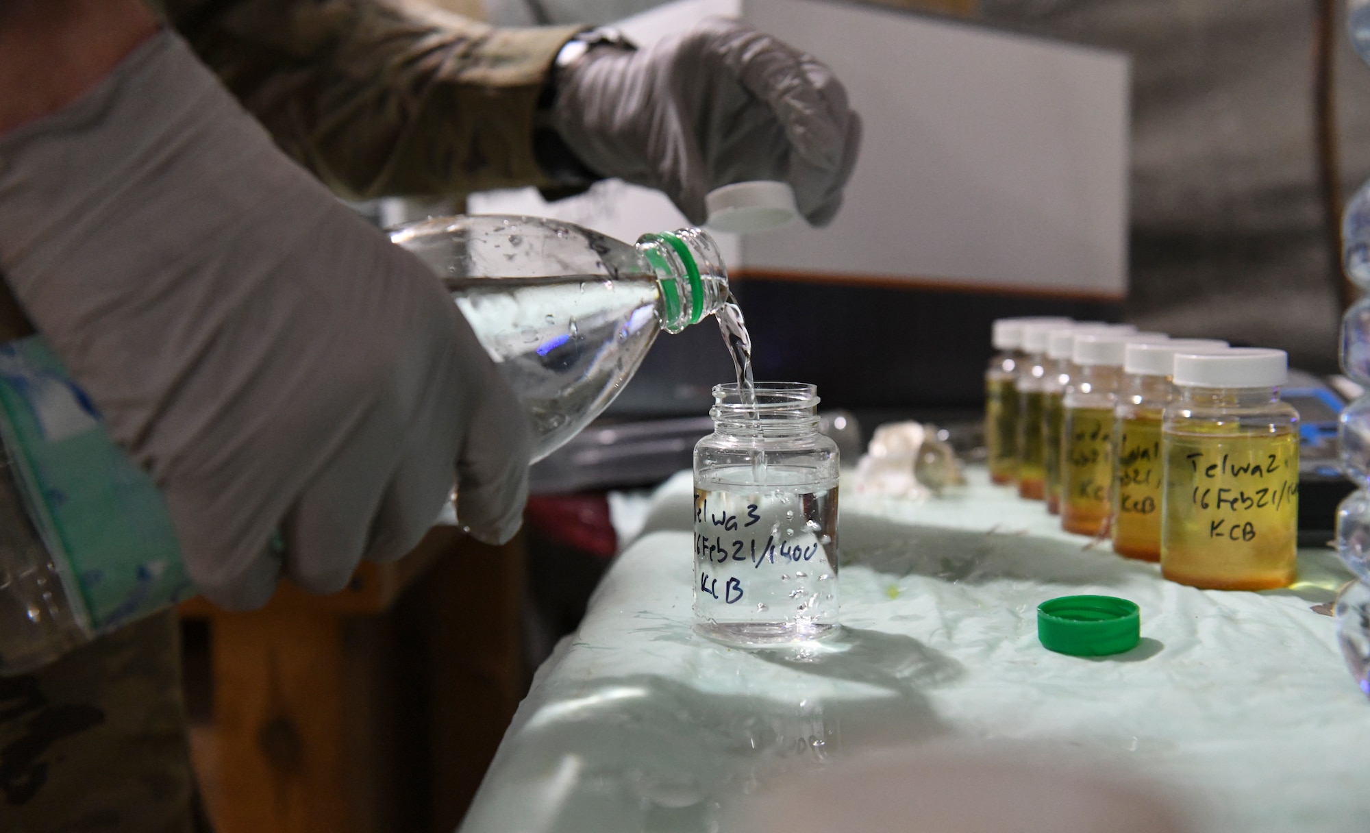 U.S. Air Force Tech. Sgt. Kristopher Beckwith, 768th Expeditionary Air Base Squadron bioenvironmental engineer, pours water into a glass jar to test the drinking quality at Nigerien Air Base 101, Niamey, Niger, Feb. 16, 2021.