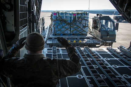 Texas Air National Guardsmen from the 181st Airlift Squadron load pallets of water on a C-130H Hercules Feb. 19, 2021, at Naval Air Station Joint Reserve Base Fort Worth, Texas. Several aircraft delivered bottled water to towns in South Texas after a devastating winter storm.