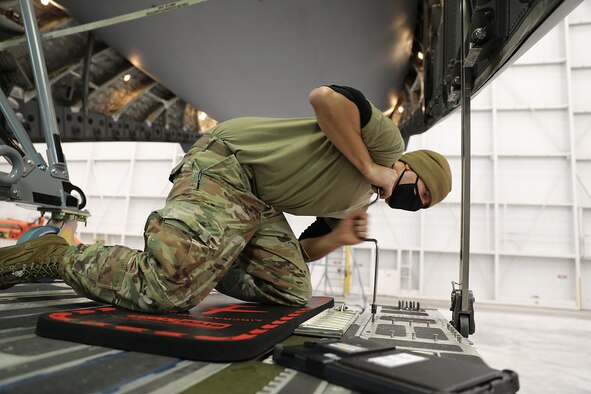 Tech. Sgt. Douglas Lippert, 445th Aircraft Maintenance Squadron crew chief, installs a floor panel on a C-17 Globemaster III aircraft. The readiness of the aircraft's interior involves removing and inspecting up to several hundred floor panels on the C-17.