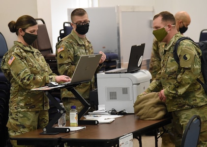 Virginia National Guard Soldiers assigned to the Virginia Beach-based 329th Regional Support Group guide VNG Soldiers returning from duty supporting law enforcement in Washington, D.C. through the reverse reception, staging, onward movement and integration process Feb. 8, 2021, at Fort Pickett, Virginia.