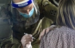 U.S. Army Spc. Jeb Hoover, assigned to the 4th Infantry Division, Fort Carson, Colorado, vaccinates a California community member at the walk-up vaccination site at California State University Los Angeles in California Feb. 20.