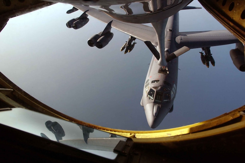 A military aircraft is refueled by another military aircraft.