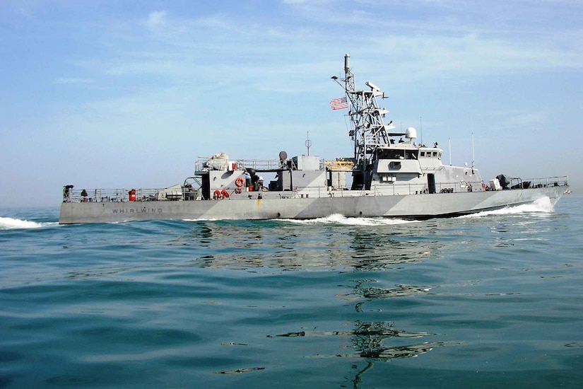 A military ship moves through the water.