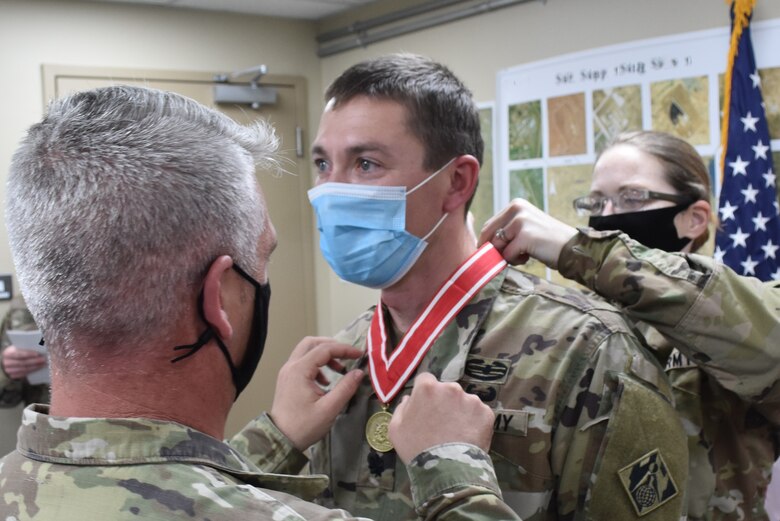 LTC Paul Sipe, outgoing Deputy Commander Afghanistan District is presented with the Bronze Order of the de Fleury Medal by Senior Enlisted Leader SGM Nathan Marshall and incoming Deputy Commander LTC Stephanie Radford in a ceremony held at Arifjan, Kuwait. (Photo by Rick Benoit)