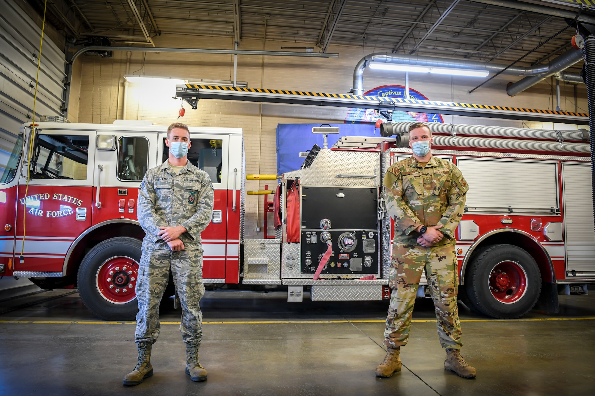 Staff Sgt. Joshua Prater and Staff Sgt. Michael Mauldin, both Fire Protection with the 179th Airlift Wing are coined by Brigadier General James R. Camp September 27, 2020, at the 179th Airlift Wing, Mansfield, Ohio. Mauldin and Prater were coined after helping save the life of an individual in a motor vehicle accident on their way to work. (U.S. Air National Guard photo by Senior Airman Alexis Wade)