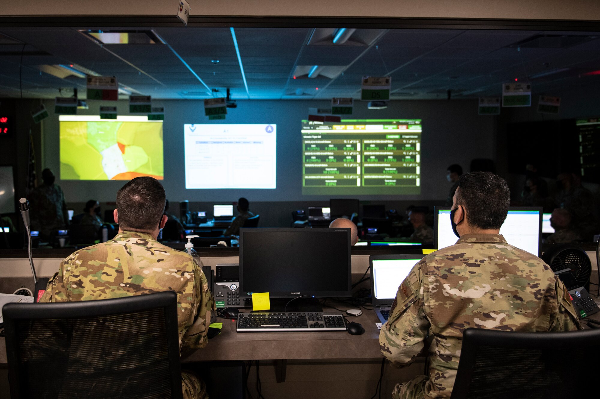 A photo of two Airmen sitting in front of their computers.