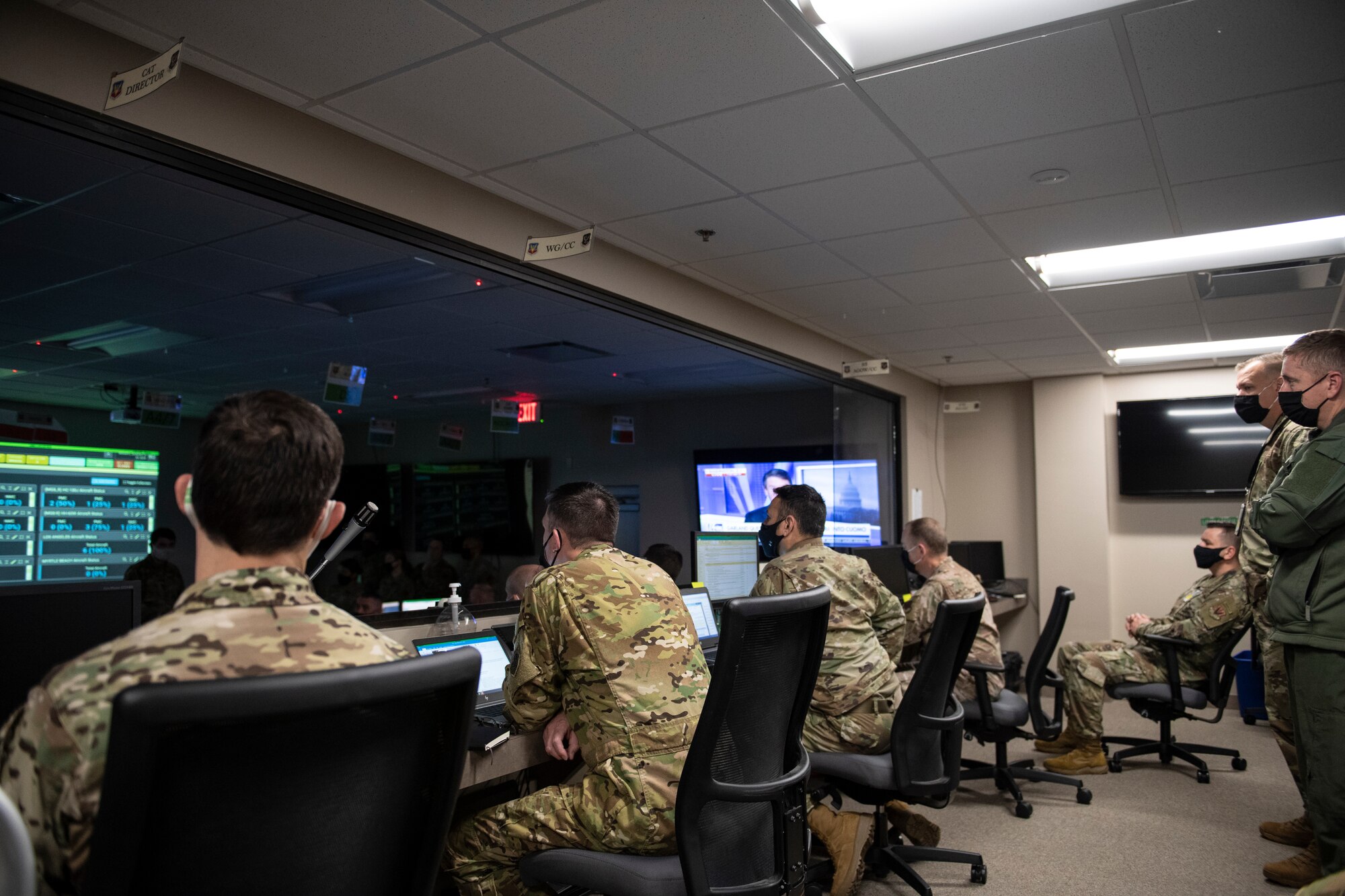 A photo of four Airmen sitting in a row in front their computers.