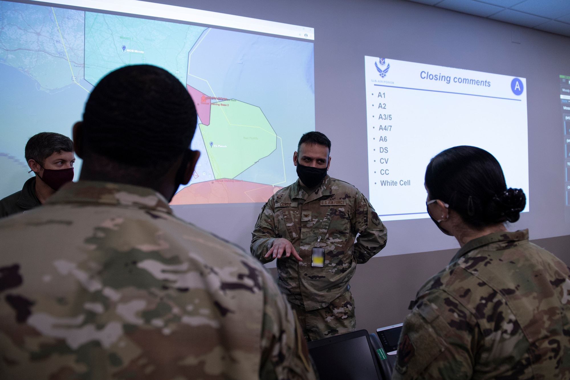 A photo of Airmen standing and talking to each other.