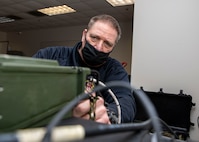 Ron Lockerby, a Joint Task Force Civil Support telecommunications engineer, configures a AN/PRC-117G Tactical Satellite Radio during a command post training exercise on Fort Bragg, N.C., Feb. 24, 2021.