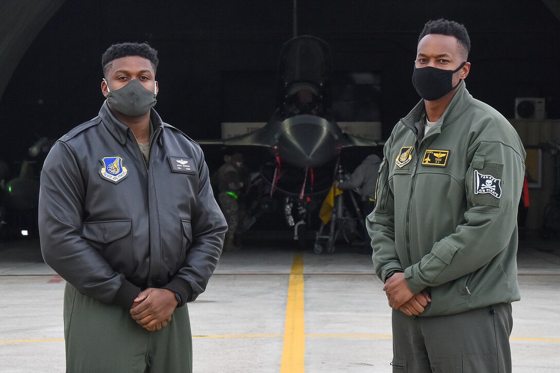 Maj. Douglas "Bane" Jenkins, 8th Fighter Wing Advanced Programs Office program manager, and Maj. Chris "Tuco" Harrison, 8th Fighter Squadron assistant director of operations and chief of standards and evaluations, pose for a photo in front of an F-16 Fighting Falcon on the flightline at Kunsan Air Base, Republic of Korea, Feb. 17, 2021. Harrison and Jenkins attended Tuskegee University together and are now both assigned to the same unit at the Wolf Pack. (U.S. Air Force photo by Senior Airman Suzie Plotnikov)
