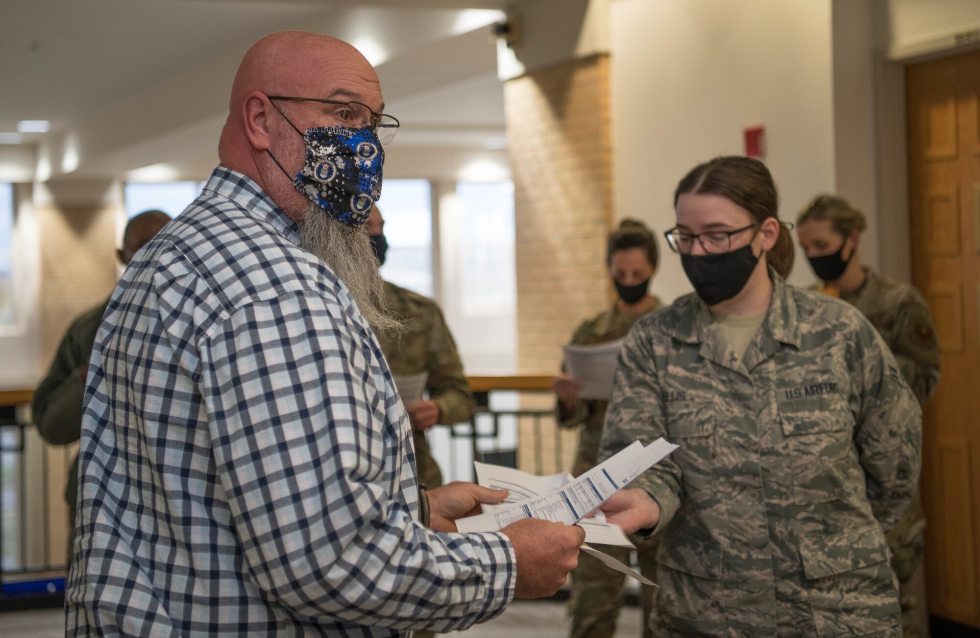 John Henry, 42nd Medical Group medical readiness flight chief, hands out travel itineraries to Airmen at the 42nd MDG at a deployment send-off on Maxwell Air Force Base, Ala. June 18, 2020. Airmen took their itineraries and received instructions from their leadership the day before their departure.
