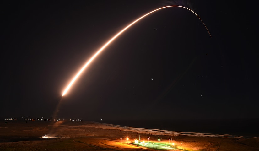 A trail of flames forms an arc in the night sky.