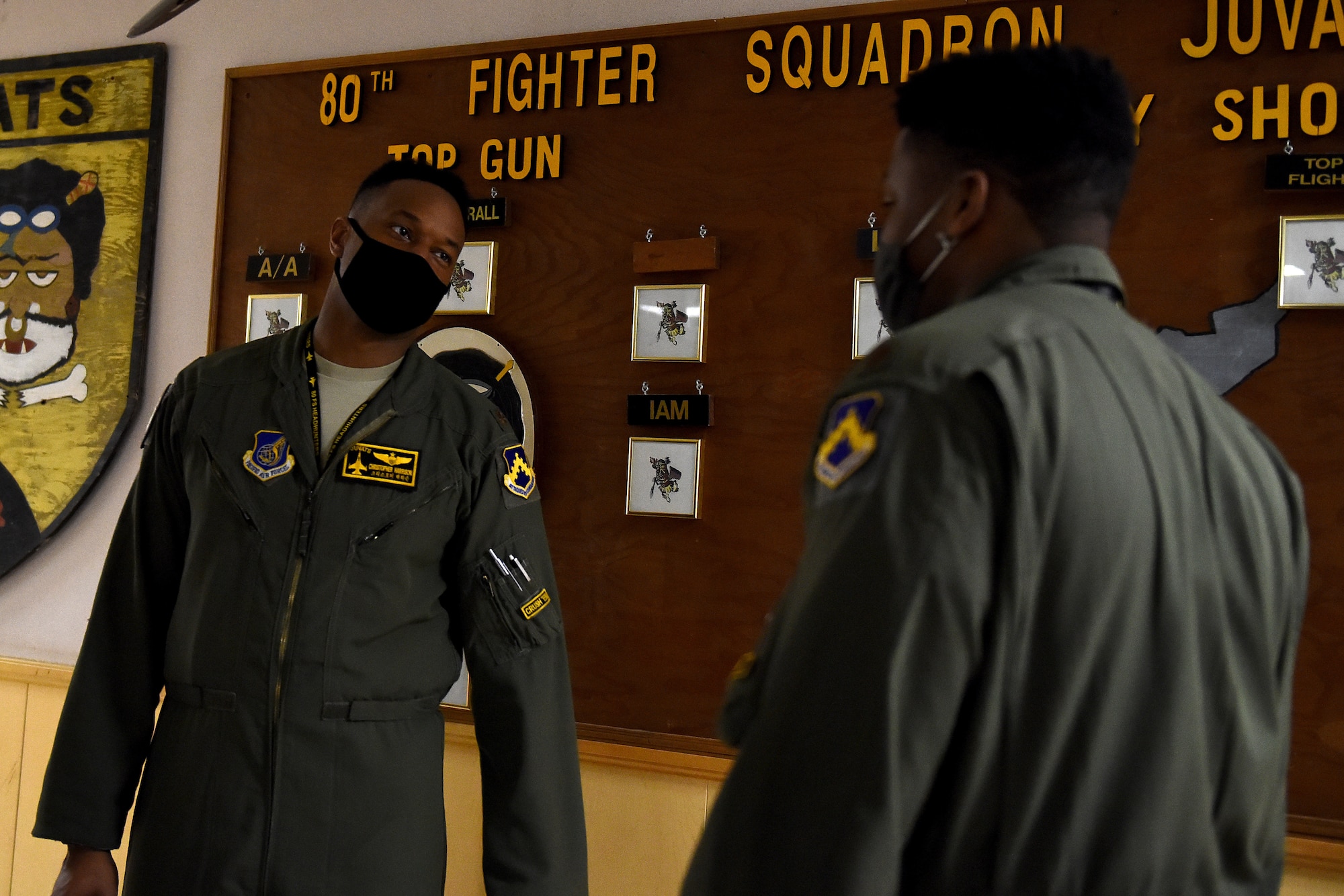 Maj. Chris "Tuco" Harrison, 8th Fighter Squadron assistant director of operations and chief of standards and evaluations, and Maj. Douglas "Bane" Jenkins, 8th Fighter Wing Advanced Programs Office program manager, talk inside the 80th FS at Kunsan Air Base, Republic of Korea, Feb. 17, 2021. Harrison and Jenkins attended Tuskegee University together and are now both assigned to the same unit at the Wolf Pack. (U.S. Air Force photo by Senior Airman Suzie Plotnikov)