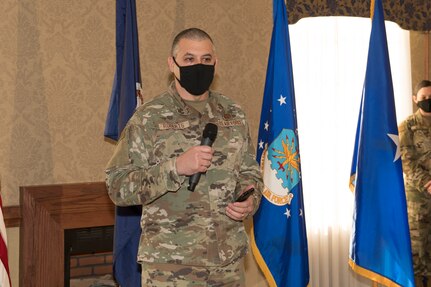 A Chief Master Sgt. speaks into a microphone during a ceremony