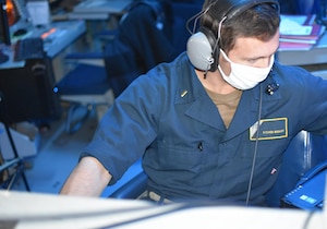 210221-N-NO146-1001 GULF OF OMAN (Feb. 21, 2021) - Ensign Steven Midkiff monitors communications in the combat information center aboard guided-missile cruiser USS Port Royal (CG 73) during a joint air defense exercise in the Gulf of Oman, Feb. 21. Port Royal is deployed to the U.S. 5th Fleet area of operations in support of naval operations to ensure maritime stability and security in the Central Region, connecting the Mediterranean and Pacific through the western Indian Ocean and three critical chokepoints to the free flow of global commerce. (U.S. Navy courtesy photo)