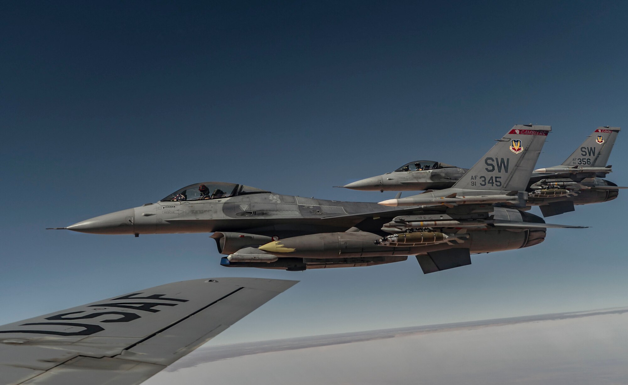 Two U.S. Air Force F-16 Fighting Falcon pilots fly alongside  a KC-135 Stratotanker, assigned to the 340th Expeditionary Aircraft Refueling Squadron, after receiving fuel while flying routine operations over Southwest Asia Feb. 16th, 2021.
