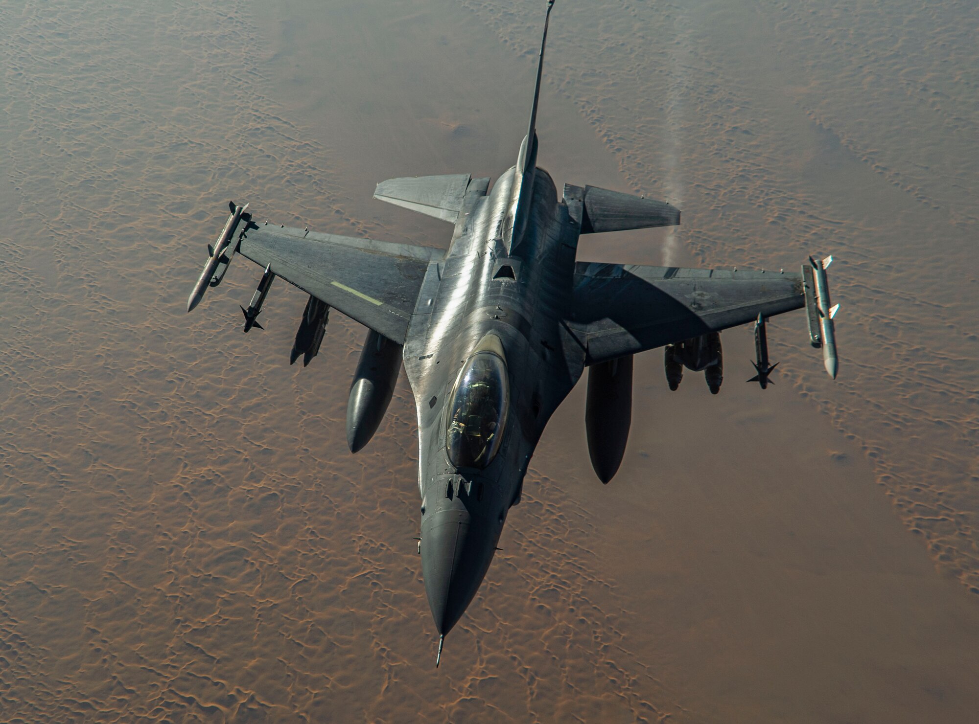 A U.S. Air Force F-16 Fighting Falcon pilot prepares to depart after receiving fuel from a KC-135 Stratotanker, assigned to the 340th Expeditionary Aircraft Refueling Squadron, while flying routine operations over Southwest Asia Feb. 16th, 2021.