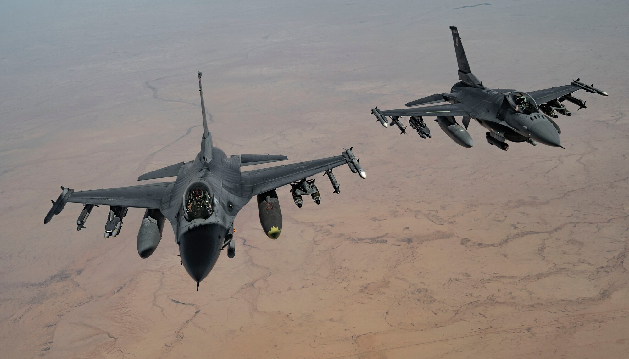 Two U.S. Air Force F-16 Fighting Falcon pilots maneuver their aircraft after receiving fuel from a KC-135 Stratotanker, assigned to the 340th Expeditionary Aircraft Refueling Squadron, while flying routine operations over Southwest Asia Feb. 16th, 2021.