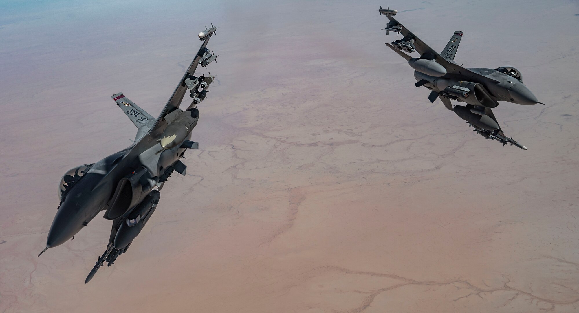 Two U.S. Air Force F-16 Fighting Falcon pilots depart after receiving fuel from a KC-135 Stratotanker, assigned to the 340th Expeditionary Aircraft Refueling Squadron, while flying routine operations over Southwest Asia Feb. 16th, 2021.