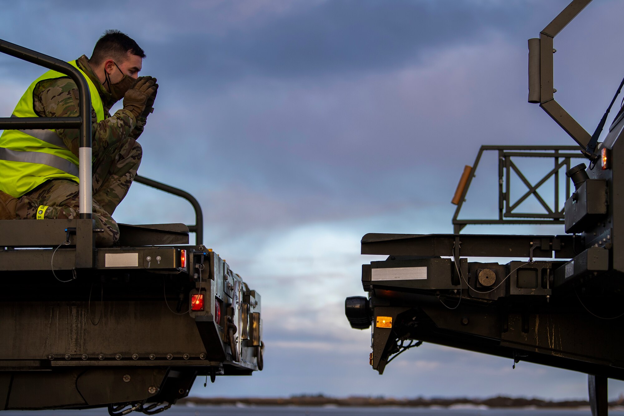 An air transportation/aerial port craftsman assigned to the 9th Expeditionary Bomb Squadron guides a Halverson 25K Loader cargo transportation vehicle at Orland Air Force Station, Norway, Feb. 21, 2021.Four C-17 Globemaster III aircraft provided logistic support by transporting Bomber Task Force Europe equipment and cargo. (U.S. Air Force photo by Airman 1st Class Colin Hollowell)