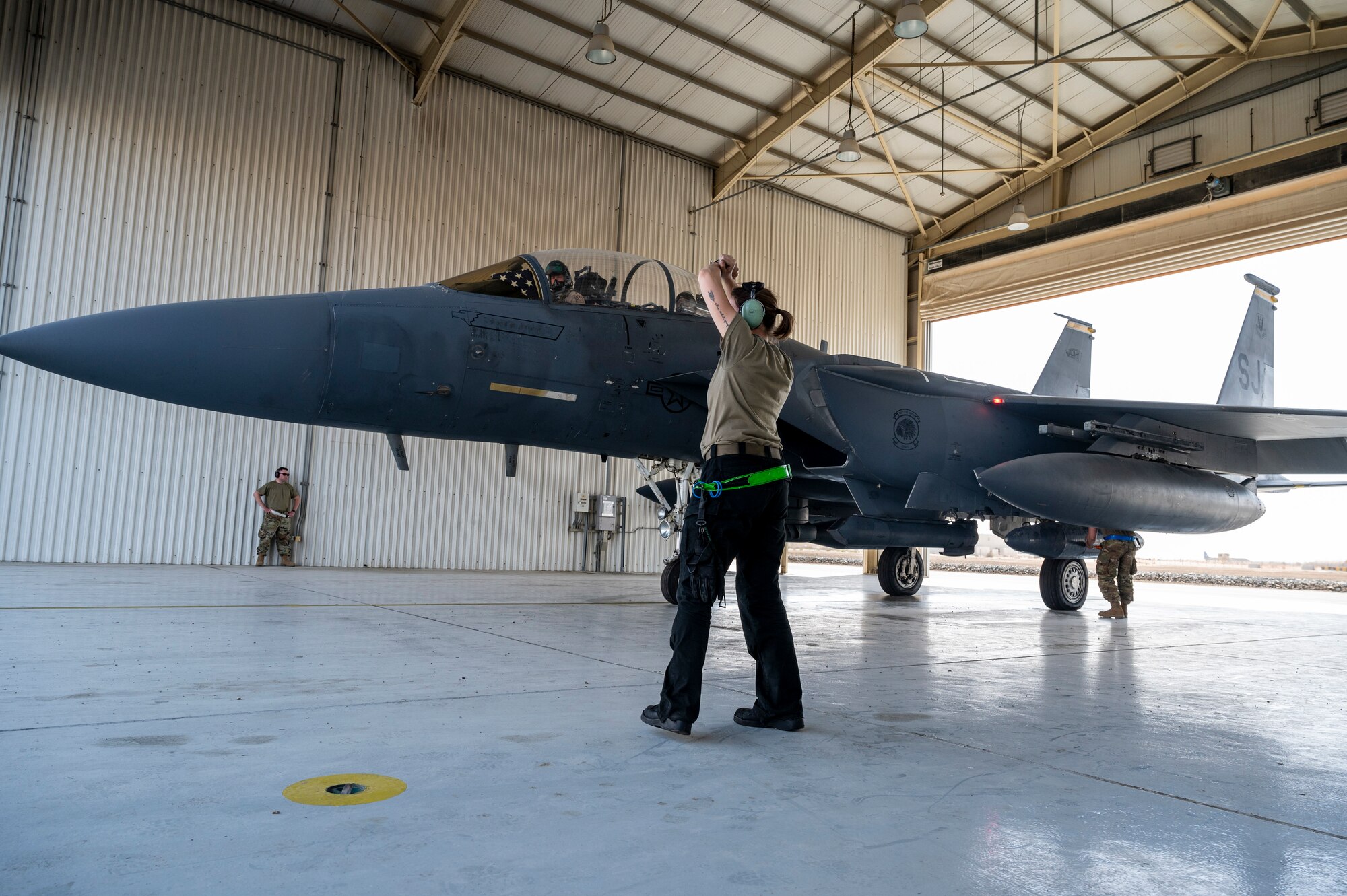 A U.S. Air Force Airman assigned to the 380th Expeditionary Maintenance Group marshals an F-15E Strike Eagle for departure at Al Dhafra Air Base, United Arab Emirates, Feb. 18, 2021.