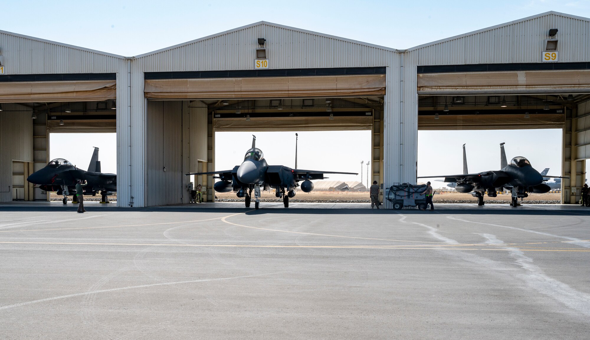 Three F-15E Strike Eagles assigned to the 335th Expeditionary Fighter Squadron prepare to taxi out during at Al Dhafra Air Base, United Arab Emirates, Feb. 18, 2021.