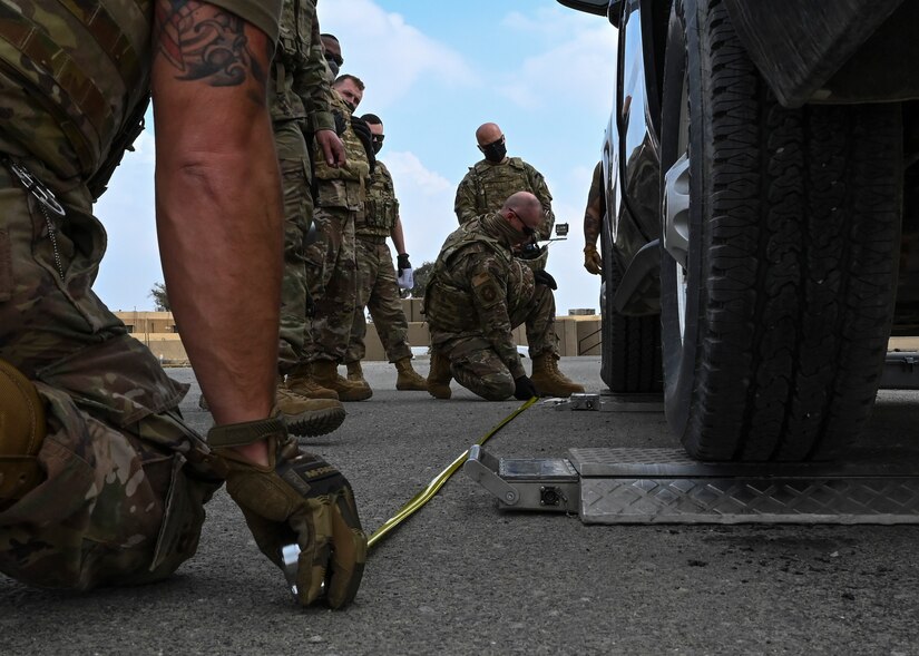 A photo of an Airman measuring a vehicle